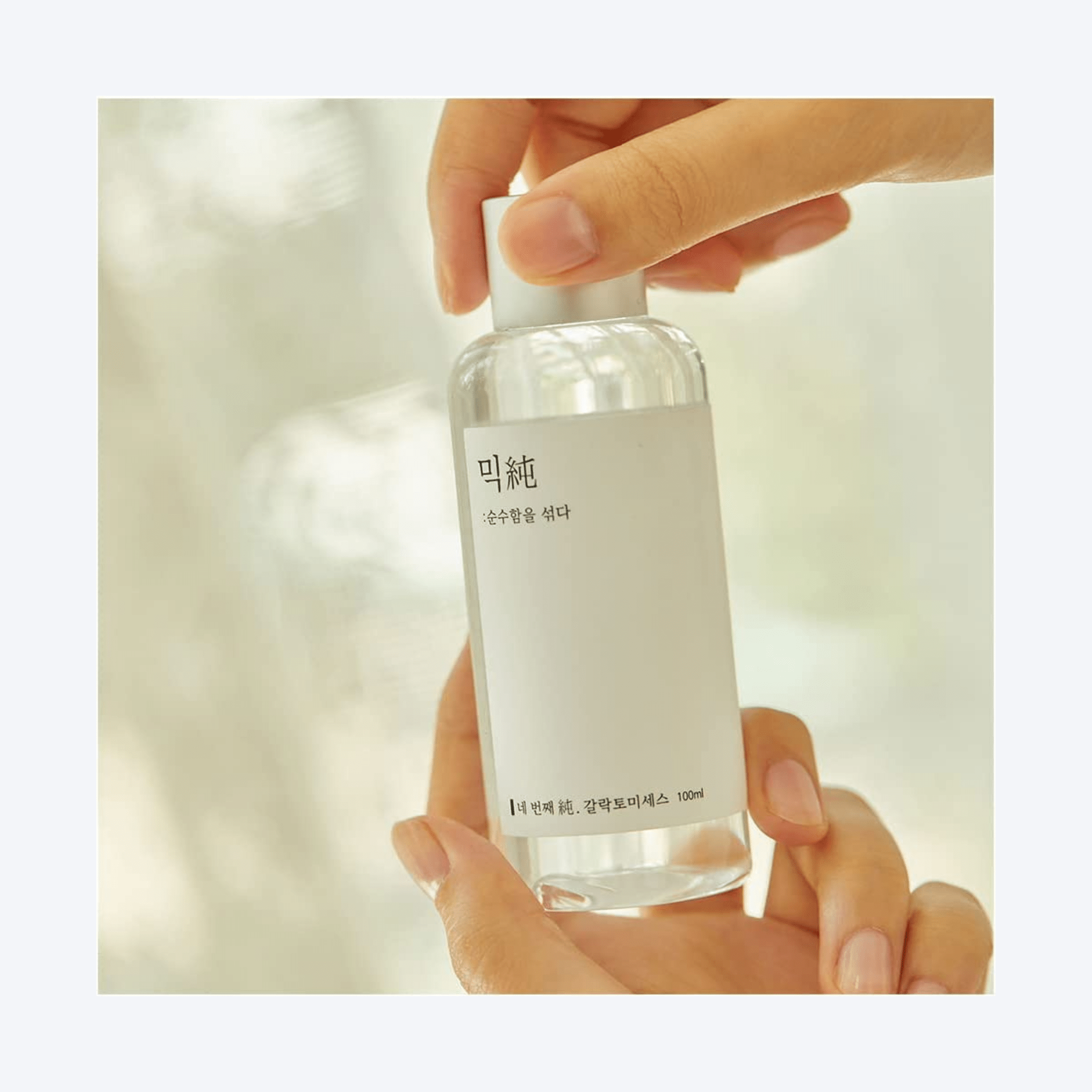 MIXSOON Galactomyces Ferment Essence Imaginea înfățișează o mână care ține cu grijă o sticlă de Mixsoon's Beta-Glucan Face Essence. Acest produs este o dovadă a angajamentului mărcii față de minimalism și eficacitate. Flaconul transparent și eticheta curată a esenței reflectă puritatea și simplitatea formulei din interior